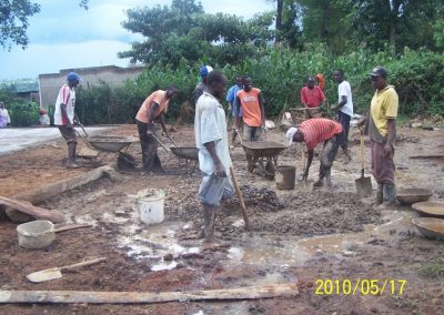 Workers mixing hardcore, sand and cement for the slab